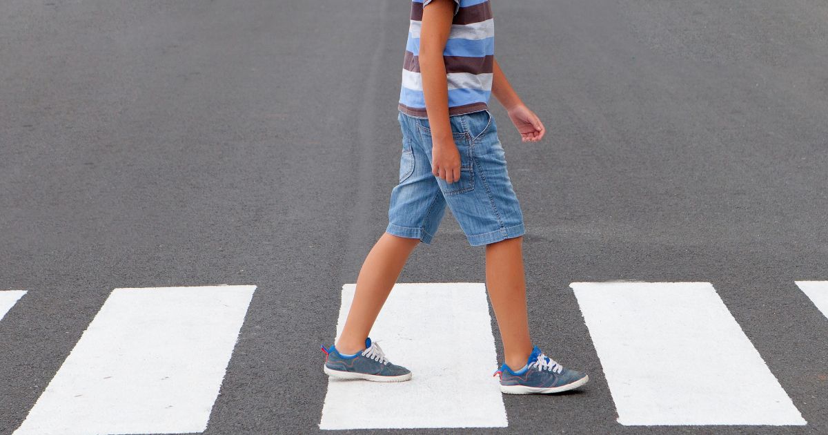 child crossing in crosswalk at intersection